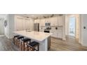 Modern kitchen with white cabinets, stainless steel appliances, and a large island at 12607 Wheatgrass Ct, Parrish, FL 34219