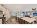 Open concept kitchen with island, stainless steel appliances, and views into the living room at 12607 Wheatgrass Ct, Parrish, FL 34219