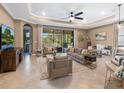 Spacious living room with tile floors, plush seating, and large sliding glass doors at 17459 Hickok Belt Loop, Bradenton, FL 34211