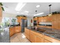 Bright kitchen featuring granite island, wood cabinets, and stainless steel appliances at 4419 Mangrove Point Rd, Bradenton, FL 34210