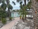 Pathway to teal cottage surrounded by palm trees at 4510 Banan Pl, Sarasota, FL 34242