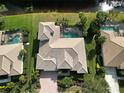Aerial view of a home with a pool, well-manicured landscaping, and close proximity to a pond at 505 Sand Crane Ct, Bradenton, FL 34212