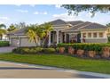 Gorgeous home with a three-car garage, palm trees, lush landscaping, and a welcoming facade at 505 Sand Crane Ct, Bradenton, FL 34212