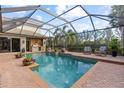 Relaxing screened-in pool area with a waterfall feature, outdoor kitchen, and comfortable seating at 505 Sand Crane Ct, Bradenton, FL 34212