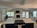 Open concept kitchen with island, white cabinets, and stone fireplace at 5317 19Th S Ave, Gulfport, FL 33707