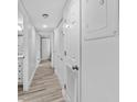 Bright hallway with light wood-look tile floors and neutral-colored walls at 5916 Midnight Pass Rd # 103, Sarasota, FL 34242