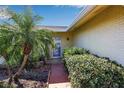 Inviting front entrance with tropical landscaping, stone pathway, and a glimpse of the home's facade at 6805 13Th Avenue W Dr, Bradenton, FL 34209