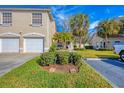 Tan two-story condo with two-car garage and manicured lawn at 7133 Cedar Hollow Cir # 22-102, Bradenton, FL 34203