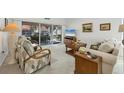 Bright living room with comfy seating, large TV, and sliding glass doors at 7133 Cedar Hollow Cir # 22-102, Bradenton, FL 34203