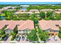 Stunning aerial view of townhomes surrounded by lush landscaping, a serene lake, and a beautiful community at 7911 Moonstone Dr # 26-203, Sarasota, FL 34233