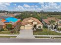 Aerial view of a tan single-story home with a three-car garage and well-maintained landscaping at 9214 Raes Creek Pl, Palmetto, FL 34221