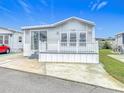 Exterior view of a well-maintained mobile home with a white deck and gray siding at 3333 26Th E Ave # 1120, Bradenton, FL 34208