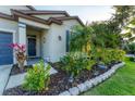 Lush front yard featuring colorful plants, mulch beds, and decorative stone edging at 10817 56Th St E, Parrish, FL 34219