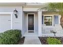 Inviting front entry with a black door and white porch at 10931 Blue Magnolia Ln, Parrish, FL 34219