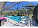 Relaxing screened-in pool and spa with lounge chairs at 11924 Forest Park Cir, Bradenton, FL 34211