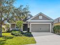 One-story home with gray siding, landscaping, and a two-car garage at 12310 Halfmoon Lake Ter, Bradenton, FL 34211