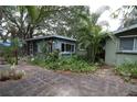 Home with a brick patio and tropical landscaping at 2311 Roselawn Cir, Sarasota, FL 34231