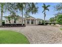 Elegant home exterior with columns, landscaping and a brick driveway at 3360 Founders Club Dr, Sarasota, FL 34240