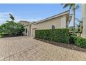 Attached garage with lush green hedge for privacy at 3360 Founders Club Dr, Sarasota, FL 34240