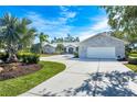 White modern home with circular driveway and palm trees at 3520 Wilderness W Blvd, Parrish, FL 34219