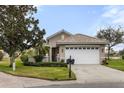 One-story house with a white garage door and lush landscaping at 4104 Reflections Pkwy, Sarasota, FL 34233