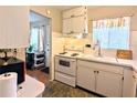 Bright kitchen featuring white appliances, tiled backsplash, and ample counter space with a window at 5918 Palm Ln # C33, Bradenton, FL 34207