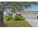 Single story home with a large tree and attached garage at 7157 Fairway Bend Cir, Sarasota, FL 34243