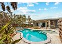 Beautiful backyard pool and spa with lush landscaping and pergola at 866 N Shore Dr, Anna Maria, FL 34216