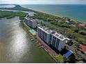 Aerial view of waterfront property, showing two buildings and surrounding landscape at 9397 Midnight Pass Rd # 603, Sarasota, FL 34242