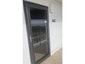 Dark brown front door with glass panels, leading to condo unit 603 at 9397 Midnight Pass Rd # 603, Sarasota, FL 34242