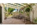 Private patio with pergola, comfortable seating, and tropical plants at 123 Pinehurst Dr, Bradenton, FL 34210