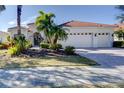 White two-story house with a three-car garage and lush landscaping at 14721 Bowfin Ter, Lakewood Ranch, FL 34202