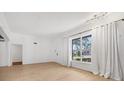 Spacious living room with large window, hardwood floors and access to hallway at 1509 Flower Dr, Sarasota, FL 34239