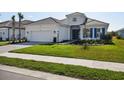 Stunning exterior of a well-manicured home with a two-car garage, verdant grass and walkway at 15610 San Lazzaro Ave, Bradenton, FL 34211