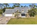 Front view of a two-story house with a gray roof and yellow siding at 17402 Billiar Ave, Port Charlotte, FL 33948