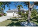 White house with grey tile roof, palm trees, and well-manicured lawn at 1929 24Th Street W Cir, Palmetto, FL 34221