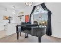 Elegant music room featuring a grand piano and large windows at 23159 Allen Ave, Punta Gorda, FL 33980