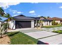 Modern home with dark garage door, paved driveway, and landscaped lawn at 2350 Via Venice, Punta Gorda, FL 33950