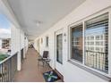 Hallway view featuring condo doors, windows, seating, and a view of the parking lot at 5903 Canal Dr # I24, Bradenton, FL 34207