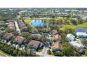An aerial view highlights community condos nestled along a serene pond and an adjacent golf course at 6706 Fairway Gardens Dr # 6706, Bradenton, FL 34203