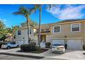 Charming two-story townhome with attached garages, landscaped entrance, and two palm trees with clear blue skies at 6706 Fairway Gardens Dr # 6706, Bradenton, FL 34203