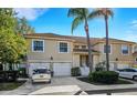 Charming two-story townhome with attached garages, landscaped entrance, and two palm trees with clear blue skies at 6706 Fairway Gardens Dr # 6706, Bradenton, FL 34203