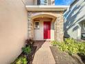 Inviting front entrance with red door and stone accents at 8267 Nandina Dr, Sarasota, FL 34240