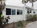 Cozy home exterior featuring white siding, mature landscaping, and updated windows at 2601 Gulf N Dr # 613, Bradenton Beach, FL 34217