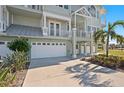 White garage doors and landscaping in front of a three-story building at 10390 Longshore Rd # 83, Placida, FL 33946