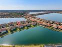 Stunning aerial view of lakeside homes with terracotta roofs in a well-maintained, planned community at 109 Porta Vecchio Bnd # 202, Nokomis, FL 34275