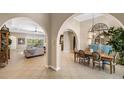 Elegant dining room with arched entryways, hardwood floors, and a charming rustic table set at 110 Asti Ct, North Venice, FL 34275