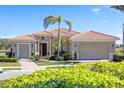 Single-story home with tile roof, two-car garage, and nicely landscaped front yard at 110 Asti Ct, North Venice, FL 34275