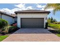 Two-car garage with paver driveway and manicured landscaping at 12251 Myrtle Bay Ct, Sarasota, FL 34238