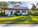 Charming white home with a red tile roof and lush lawn located in a desirable neighborhood at 1864 Clematis St, Sarasota, FL 34239